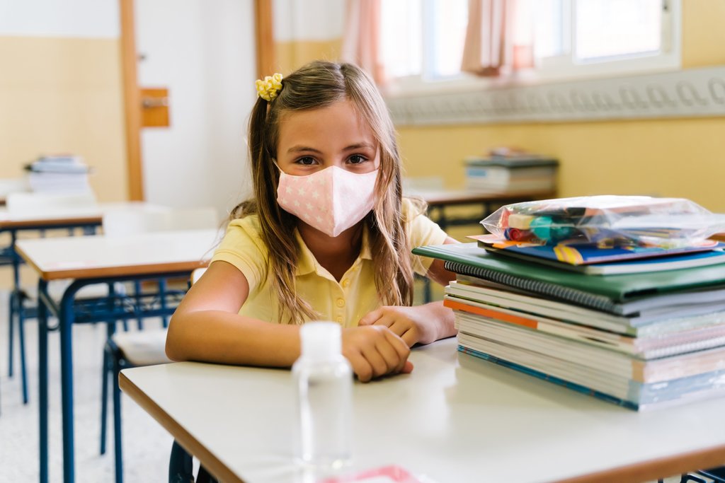 girl_sitting_at_her_chair_and_table_in_the_classroom_wearing_a_mask_to_protect_herself_during_the_covid_pandemic_1_1024_2500